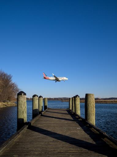 An American Airlines Airbus A319 (reg N4032T) appears over a boat launch dock while on final for DCA Runway 19.