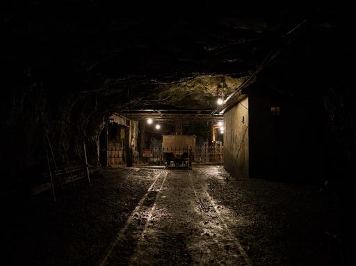 Looking at a mine cart, transfer station, and shaft at the Lansford No. 9 coal mine. This shaft (center back) extended up and down hundreds of feet, but is flooded in the present day. A transfer station (left) is a machine used to shift and rotate coal cars across different tracks when there is not enough room to use normal tracks and junctions. A small mine office is visible to the right.